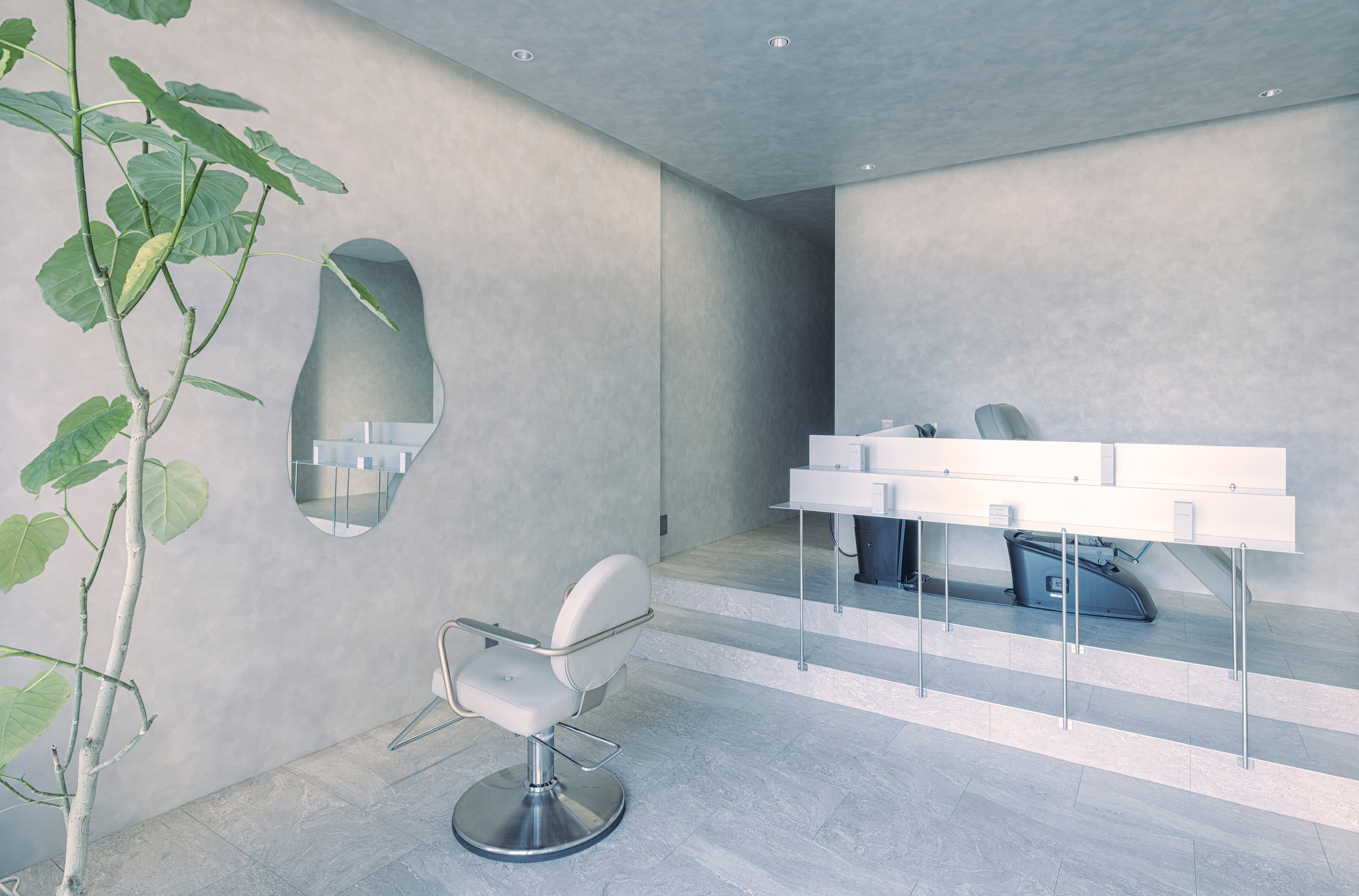 Modern minimalist ulu hair salon interior with sage green walls, professional salon chair, and natural plant decor
